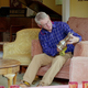 Rowan sitting on a sofa in his home, polishing a silver vase